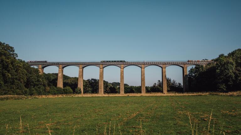 A long aqueduct crossing a wide green valley.