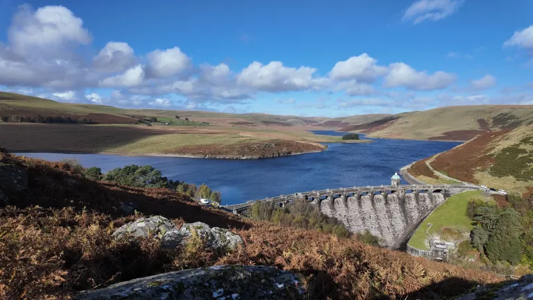 dam and reservoir on sunny day.