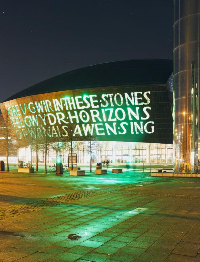 Exterior of Wales Millennium Centre and the water tower on Roald Dahl pass at night.
