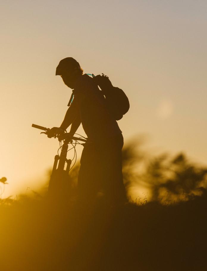 Silhouette of two people standing with their mountain bikes