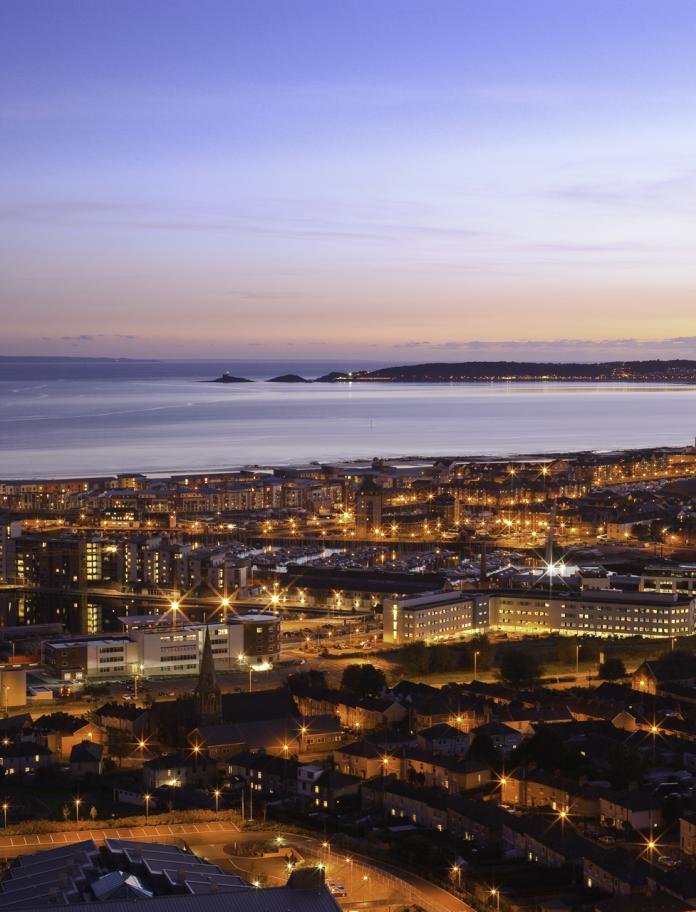 Aerial view over Swansea town at early evening toward Mumbles Head.