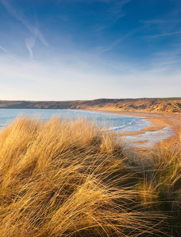 Freshwater West beach, image taken from behind dunes on a clear and calm day.