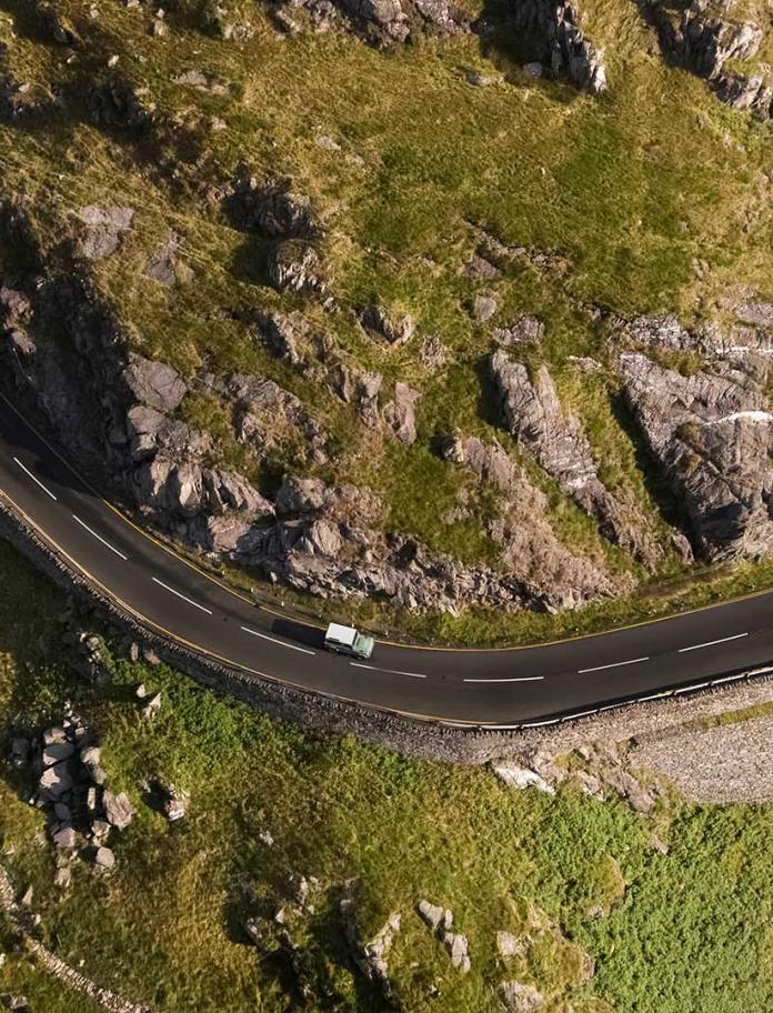 Aerial image of landrover driving around bend at Nant Gwynant.