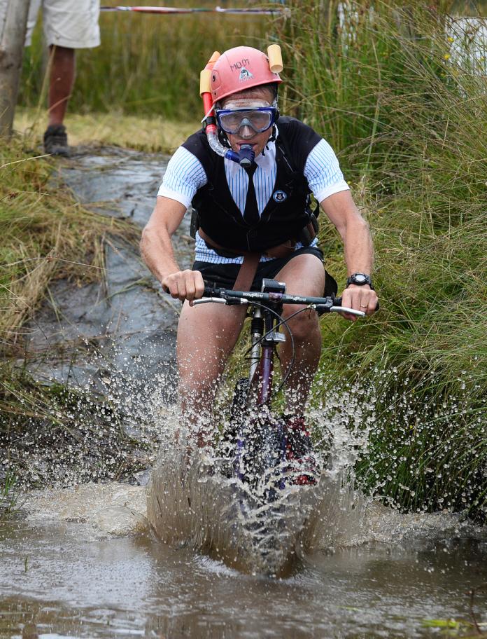 Image of a person riding a bicycle through a bog.