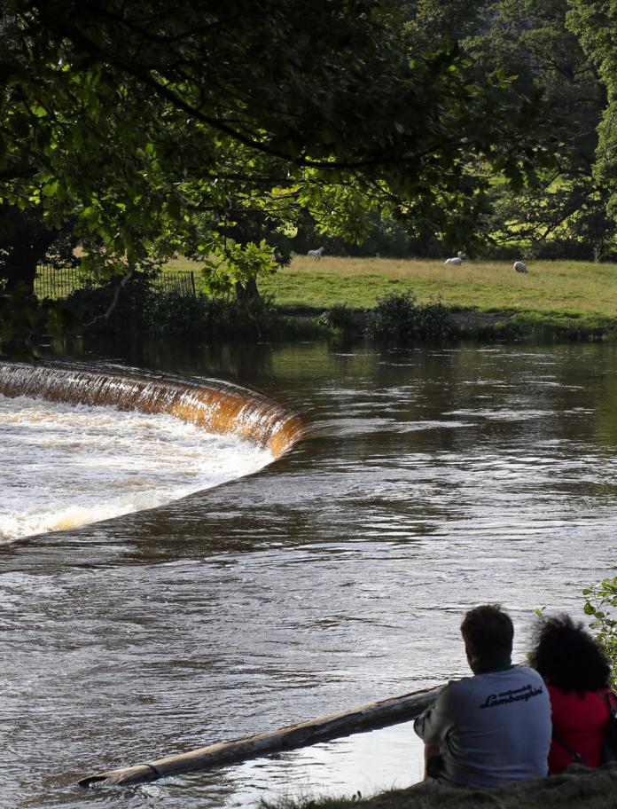 A curved weir waterfall on a river.