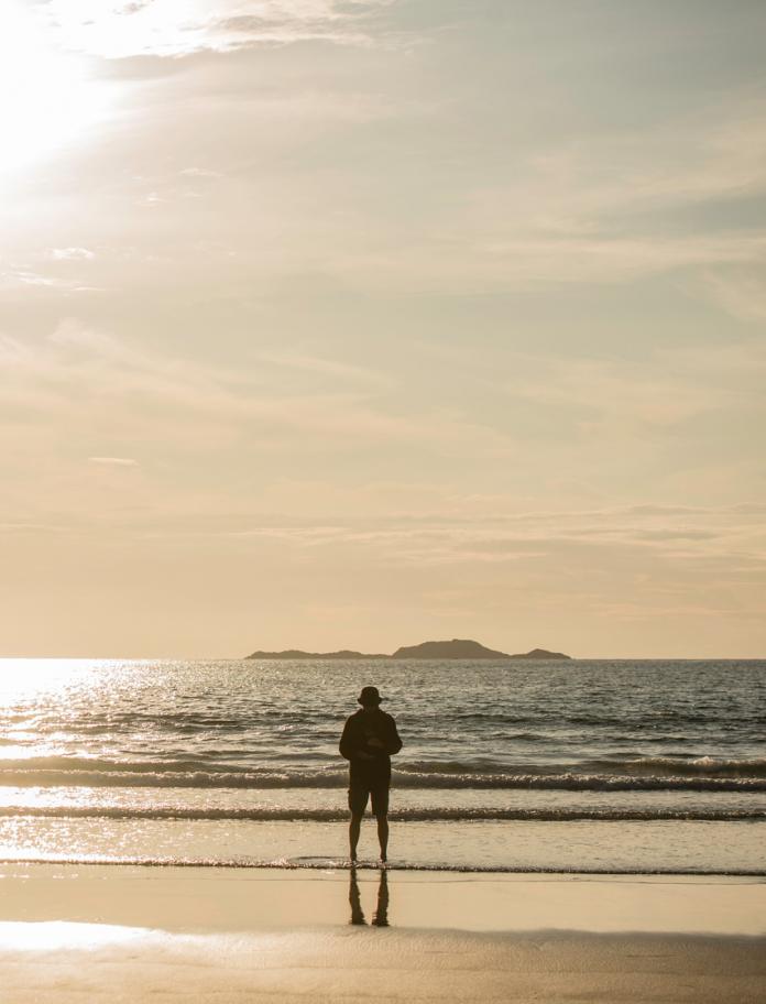 Man standing by sea at Whitesands Bay, Pembrokeshire, Westwales.