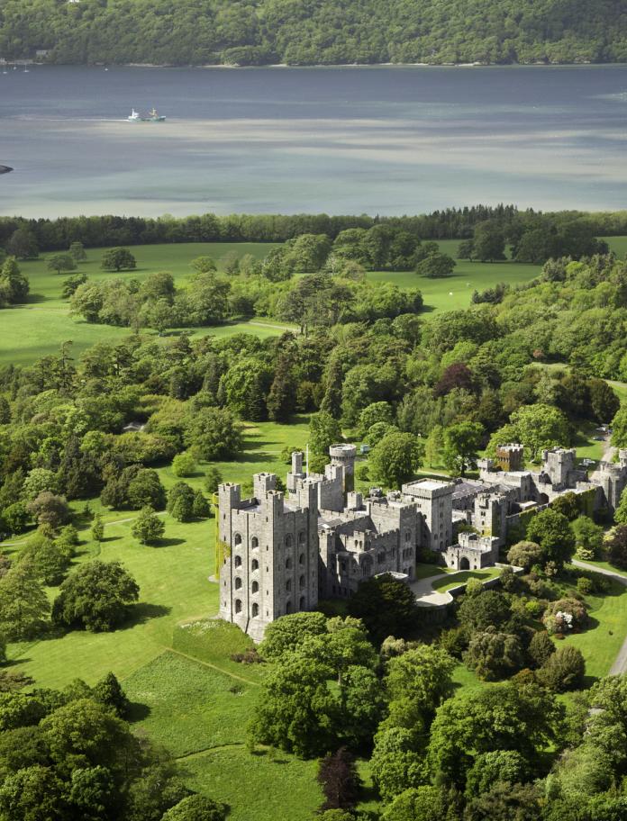 Aerial view Penrhyn Castle with Menai Strait and Porth Penrhyn in background, near Bangor, North Wales