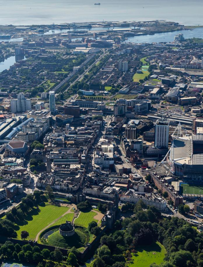 Aerial view of Cardiff city centre including a big arena,  park and river.