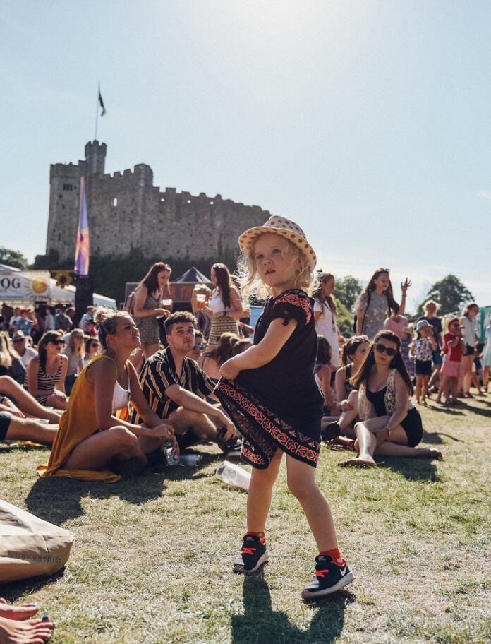 Little girl dancing at Tafwyl festival, with Cardiff Castle in the background