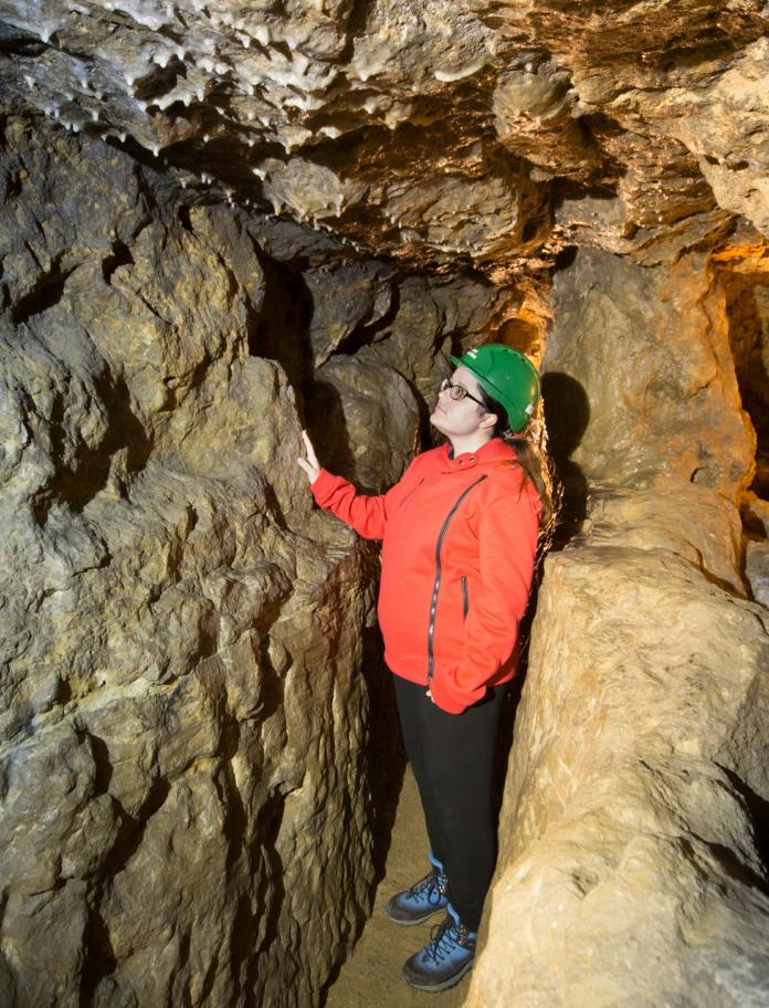 A woman in a tunnel in Great Orme Mines.