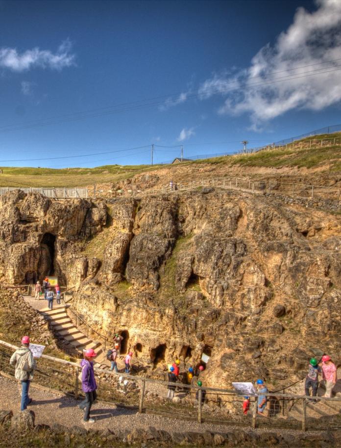 A group of people exploring the entrance to the Great Orme Mines.