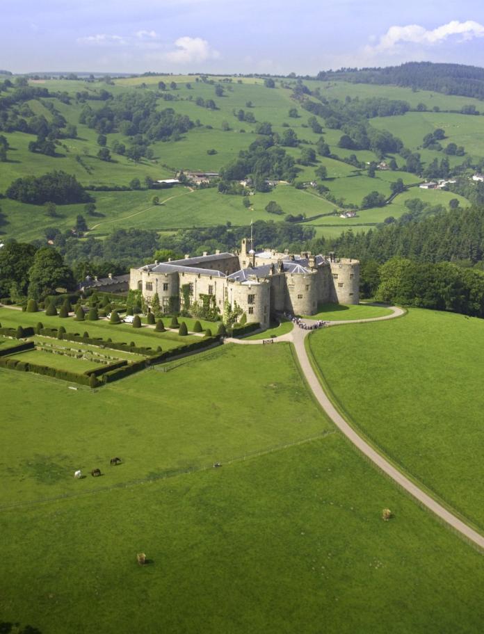 An aerial view of Chirk Castle and gardens with mountains in the background. 