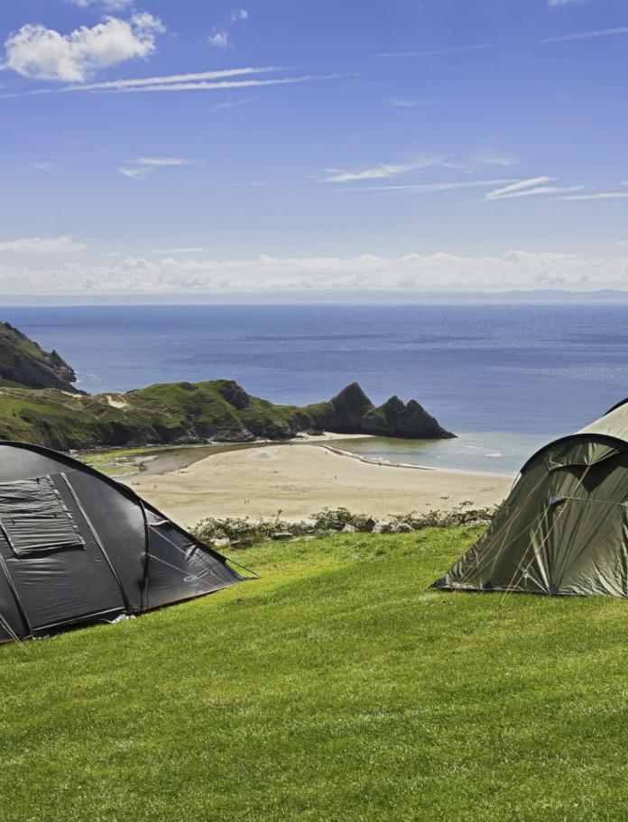 Tents at Three Cliffs Bay Holiday Park on the Gower Peninsula overlooking the beach.