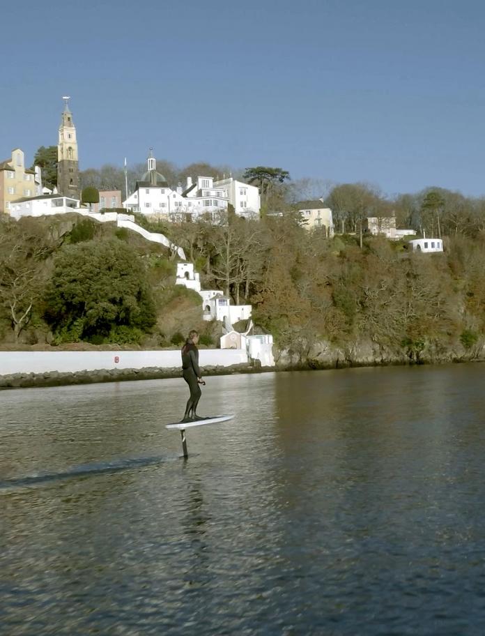 Two people using eFoil surfboards on the river by Portmeirion.