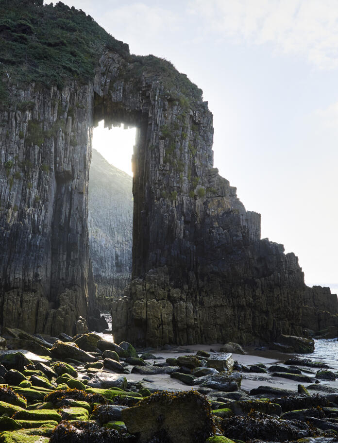A seaside rock formation with a hole through.