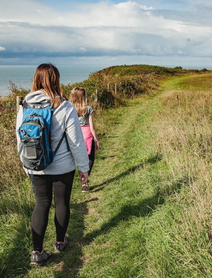 A woman and child walking along the Wales Coast Path.