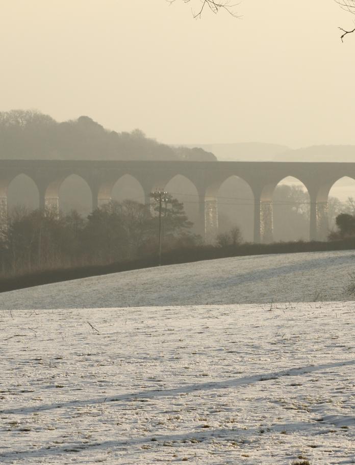 Snowy field with viaduct in the background