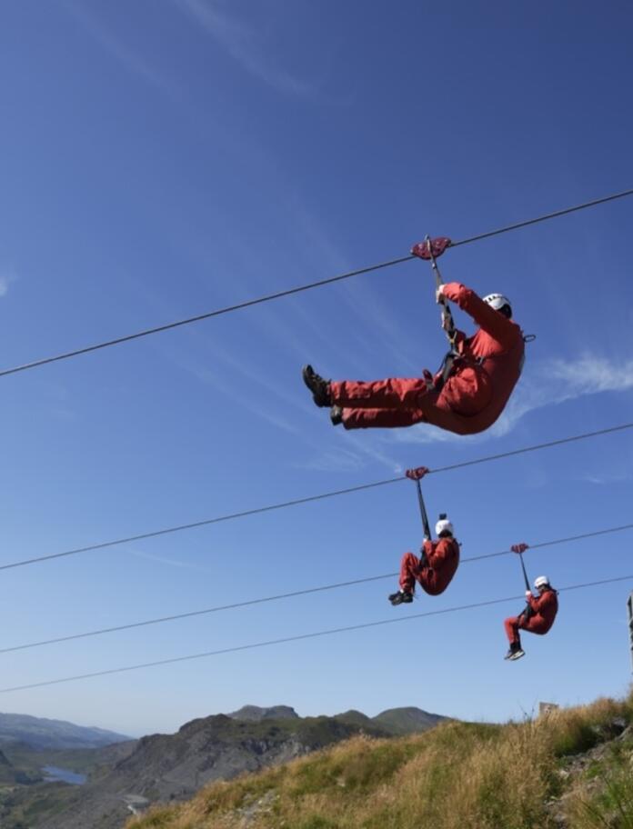 Three people on parallel zip wires
