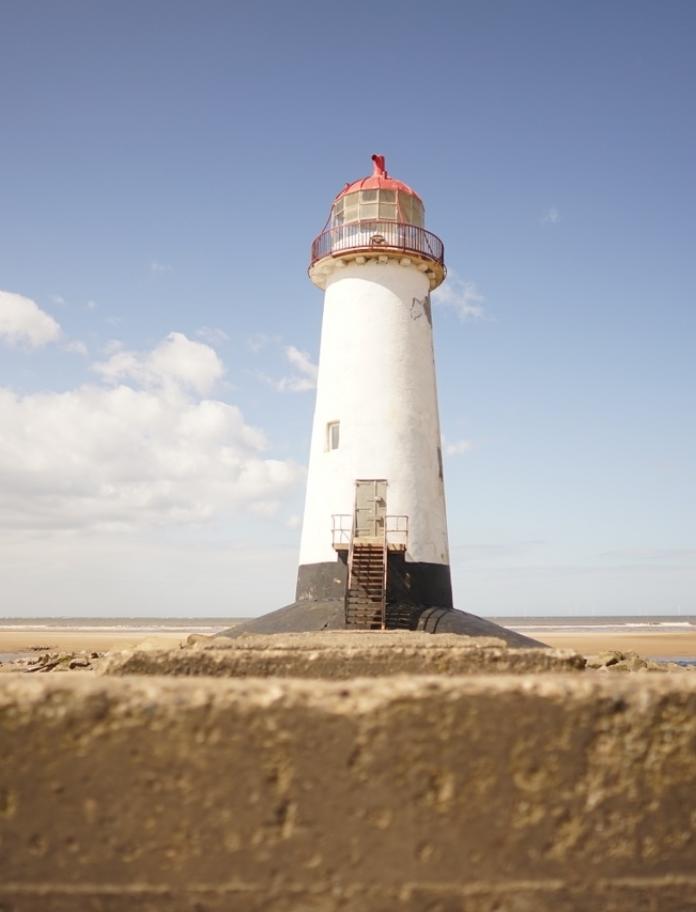 A large lighthouse on a beach.
