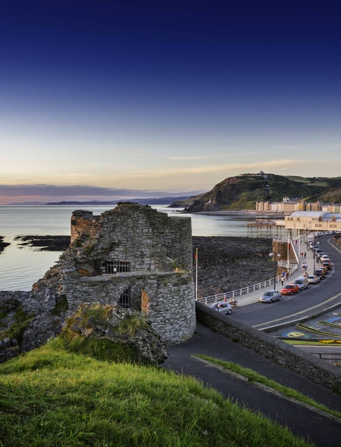 image of castle ruins and buildings along seafront.