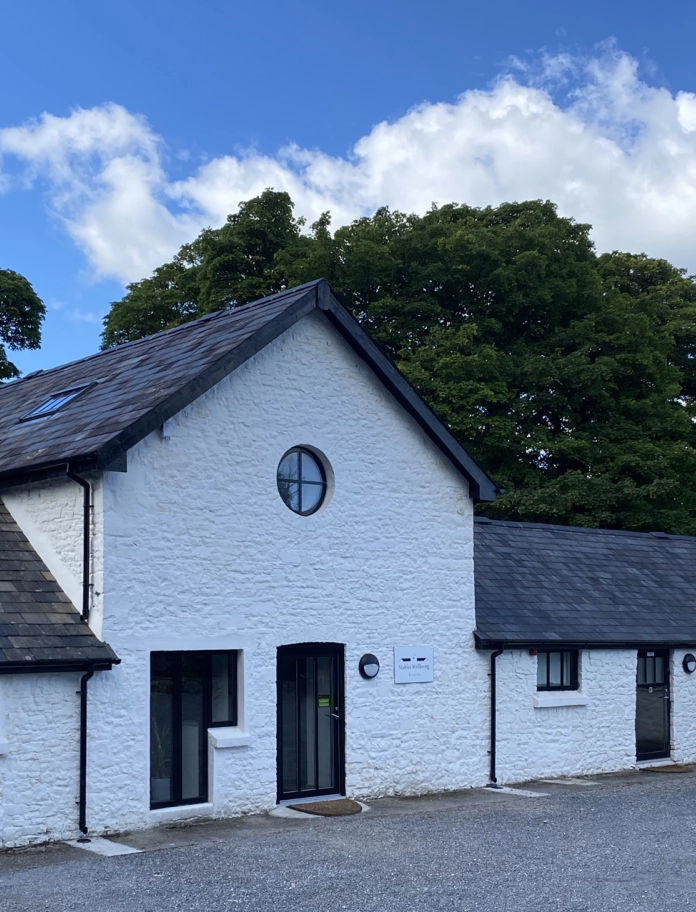 Exterior of a white painted stable building.