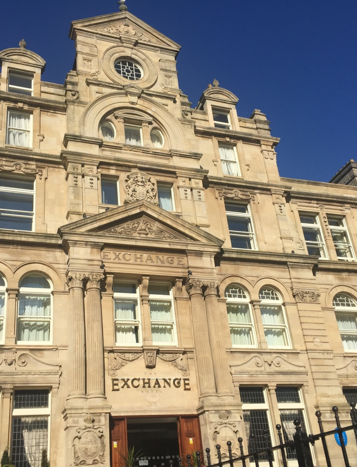 An exterior view of the Coal Exchange Hotel against a blue sky.