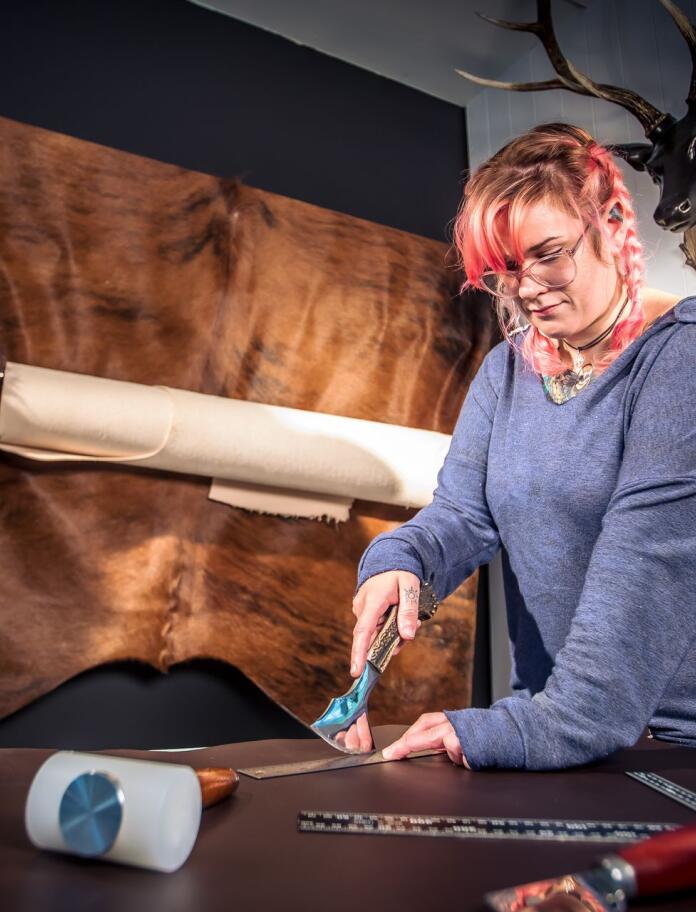 A woman using tools to craft on a table