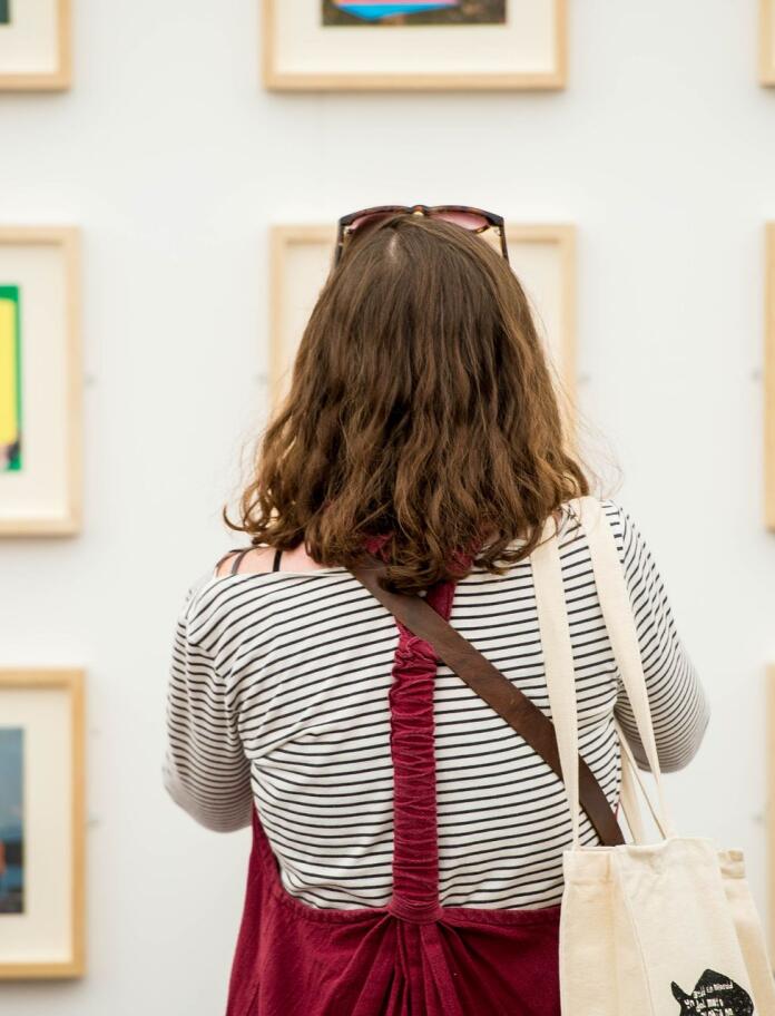 A person facing an art exhibition.