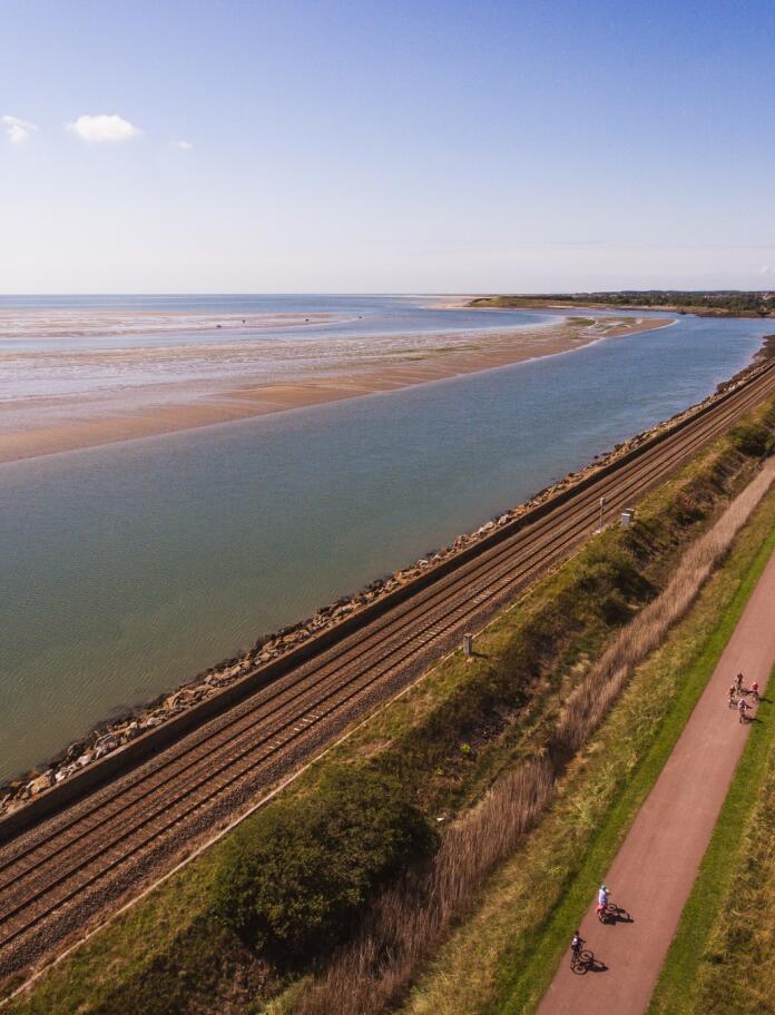 A railway line and cycle / footpath alongside an estuary.