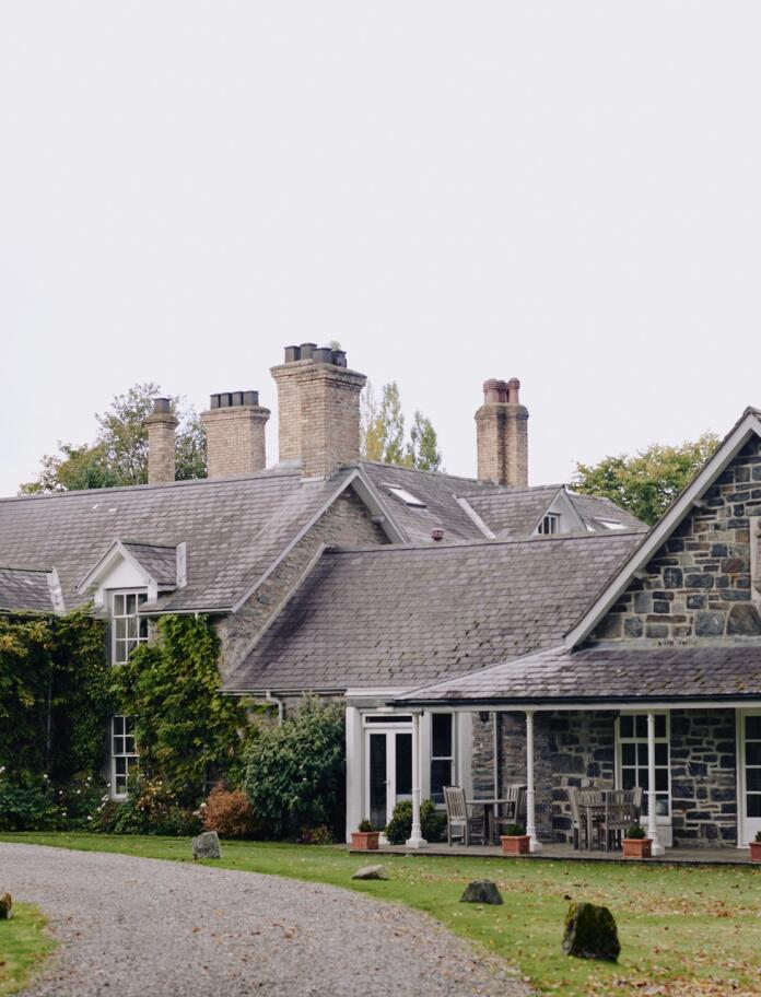 A stone built, slate roofed house with ivy on the walls.