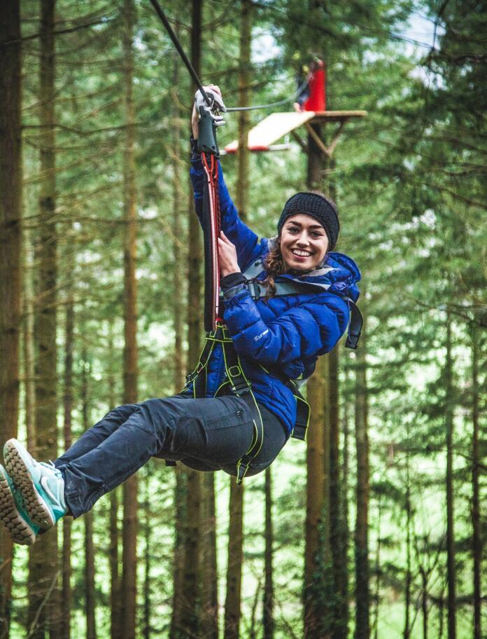 A person on a zip wire high in trees.