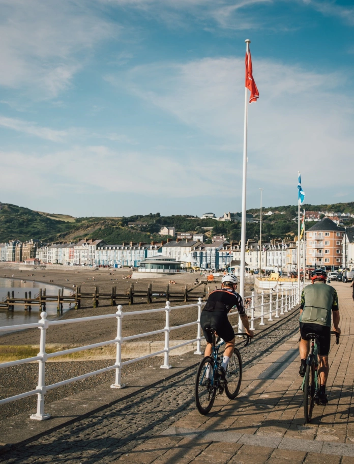 sea front with two cyclists and woman walking.