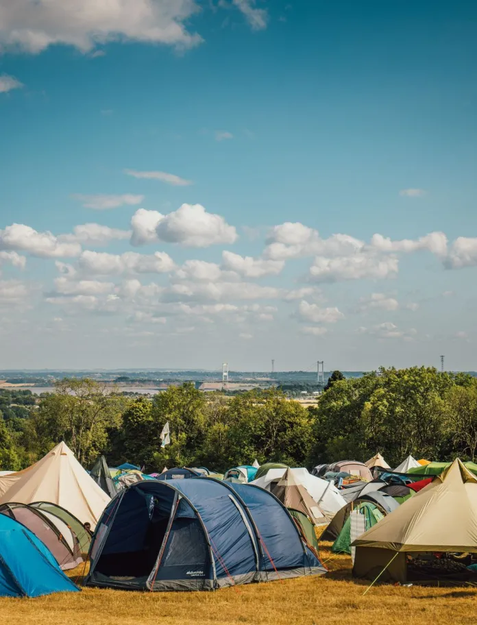 Camping field at a festival with a variety of tents. 