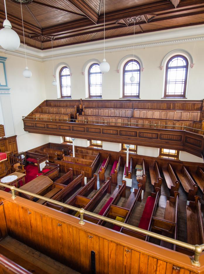 looking down into interior of church with wooden pews.