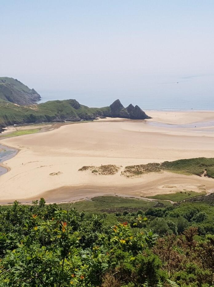 A view of a sandy beach and cliffs