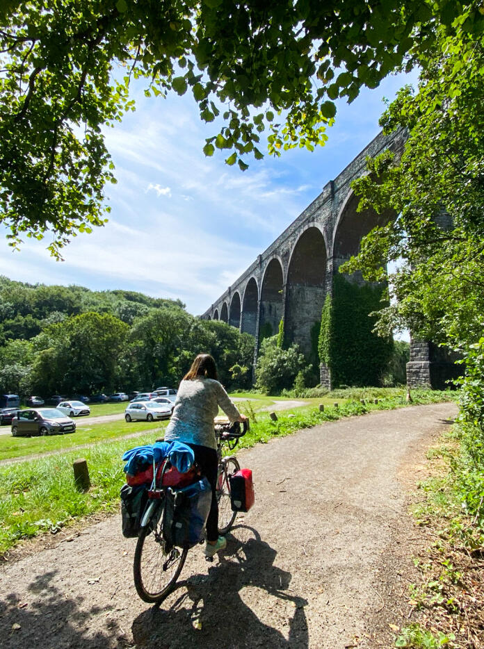 A person cycling through a park and under the viaduct