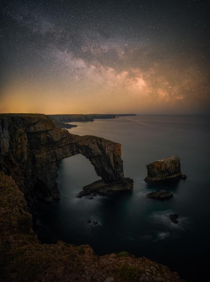 Milky Way above coast with sea archway.