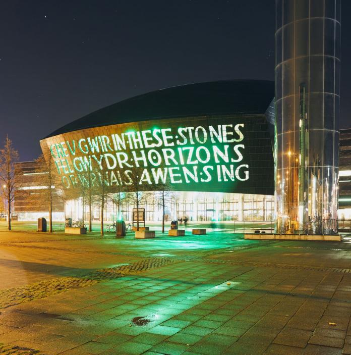Exterior of Wales Millennium Centre and the water tower on Roald Dahl pass at night.
