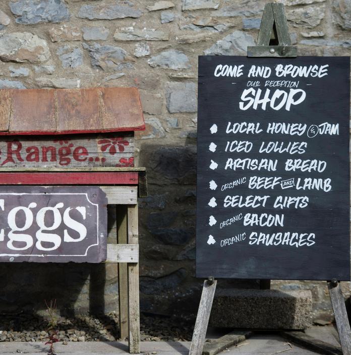 Schilder für einen Hofladen, der für Eier und andere Hofwaren wirbt.