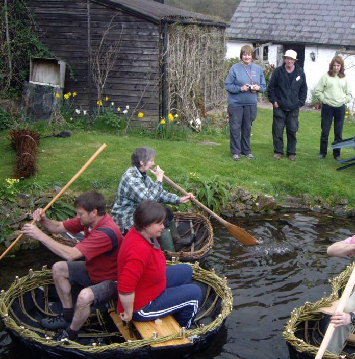 Image of people using coracles in a pond