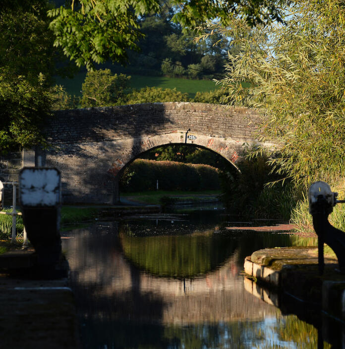 View from a canal lock towards a bridge over the water.