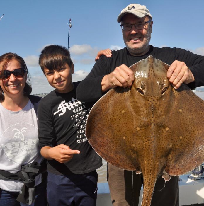 A  family hold up a blonde ray.