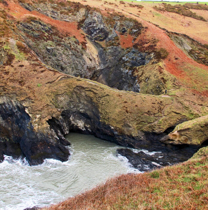 autumn colours on cliffs with caves and sea.