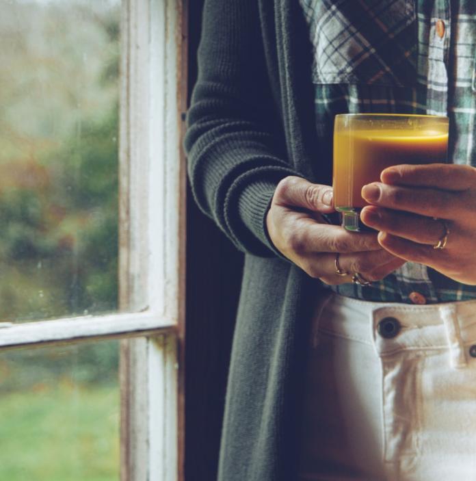 Picture of hands holding a glass cup with a turmeric latte
