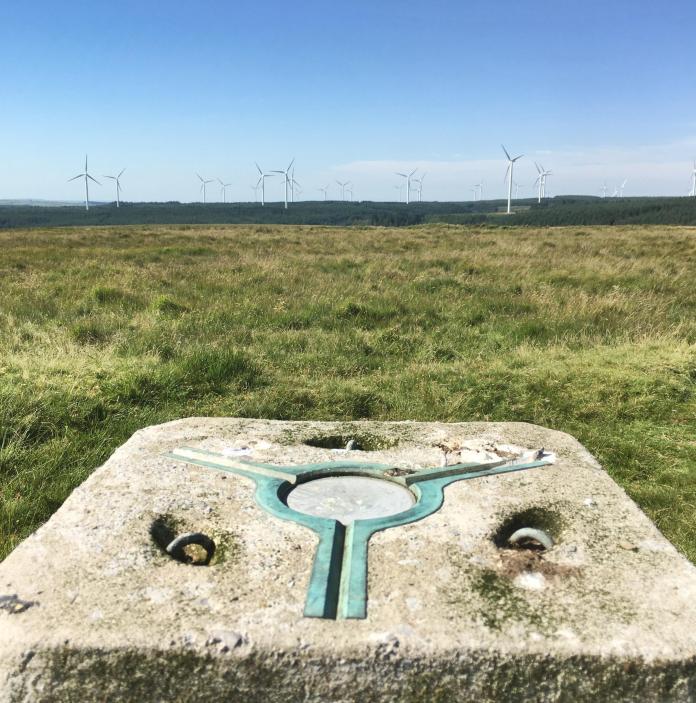 Trig point from which you can view a wind farm.
