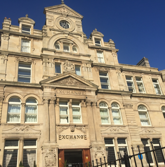 An exterior view of the Coal Exchange Hotel against a blue sky.