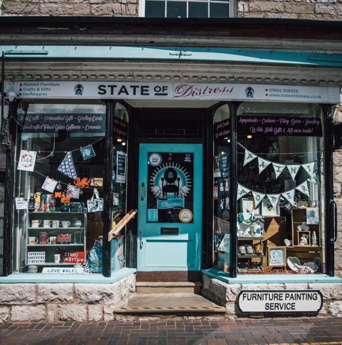A double fronted shop with a turquoise door.