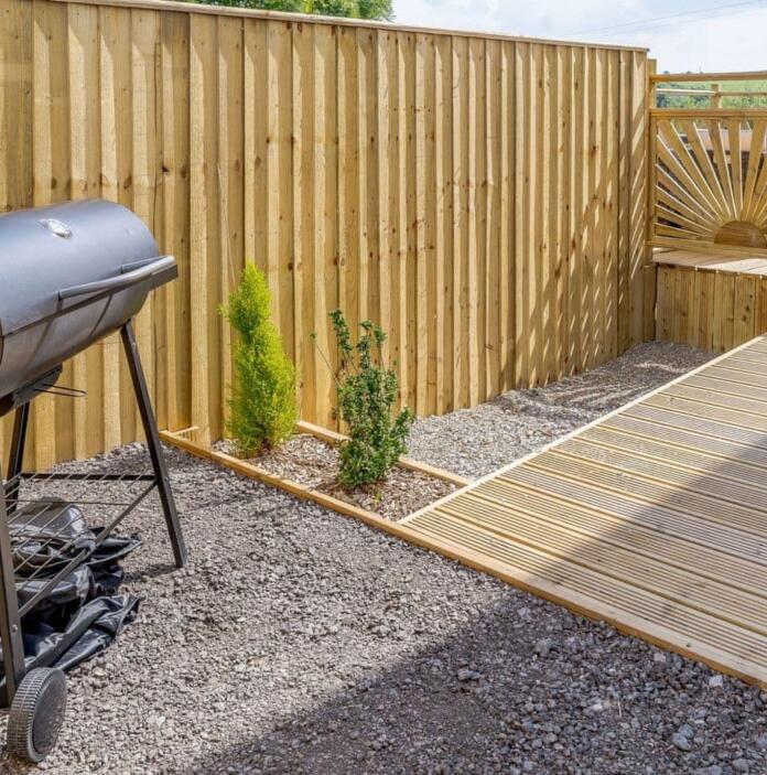 garden with ramped walkway and barbeque.