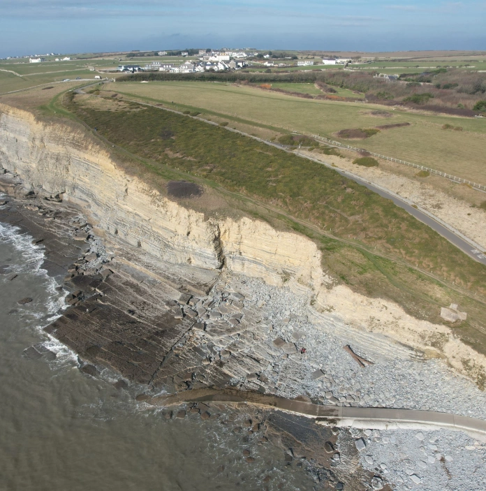 Aerial view of a limestone cliff edged coastline with rocky beaches.