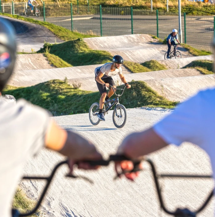 Two bike riders watching another.
